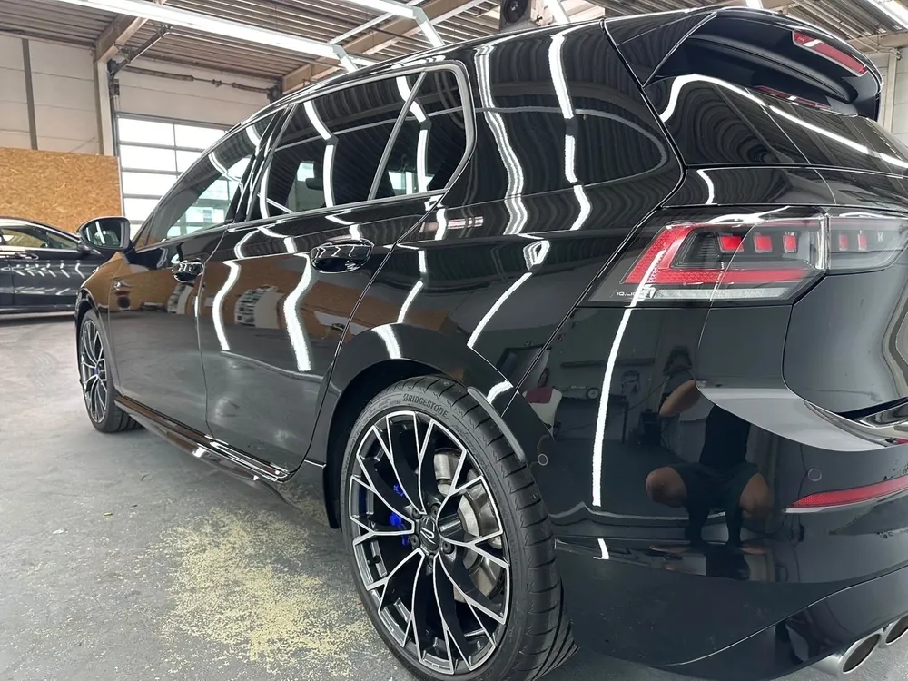 Schwarzer VW Golf R mit Hochglanzpolitur und blauen Bremssätteln nach der Aufbereitung