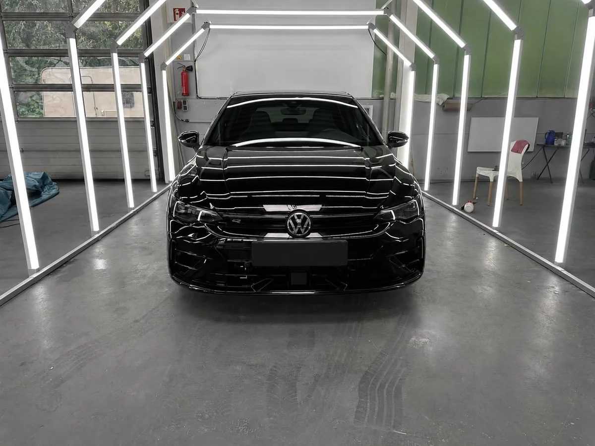 Schwarzer VW Golf R mit frisch aufbereitetem, spiegelndem Hochglanzlack in der Aufbereitungs-Lichtbox von Emder Lack & Glanz